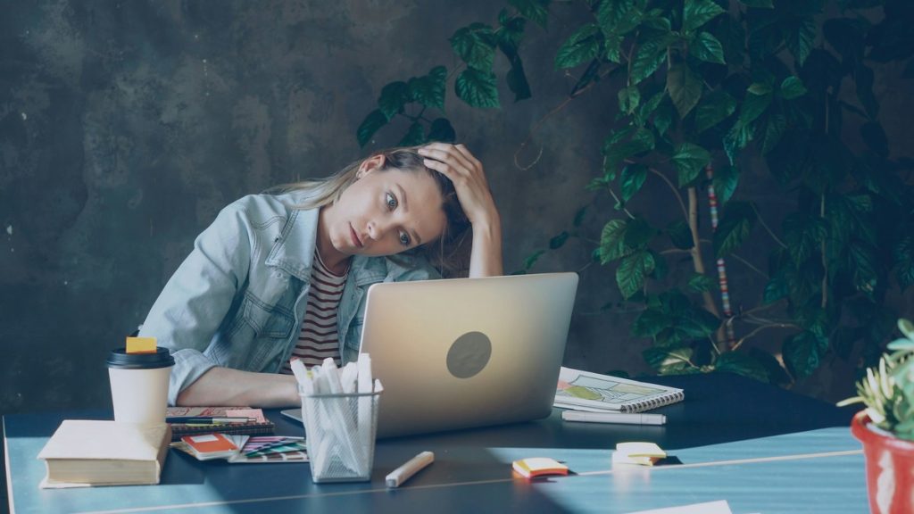 Person sitting at desk looking exhausted after deciding to quit job due to stress