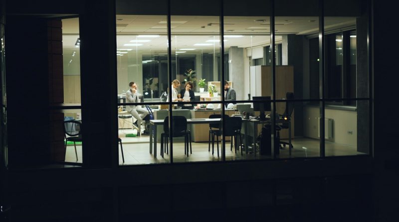 An exhausted office worker experiencing AI burnout late at night